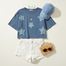 Load image into Gallery viewer, Flat lay of Patchwork Star Cropped Tee with denim shorts and denim cap