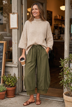 Load image into Gallery viewer, Softly Yours beige mock neck sweater styled with olive lace-trim pants at a café
