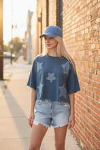 Load image into Gallery viewer, Patchwork Star Cropped Tee styled with light wash denim shorts and denim cap outdoors